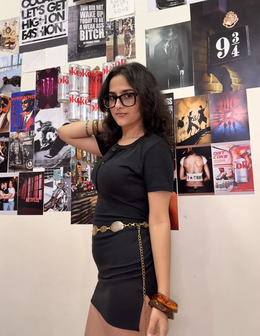 baddie wall decor - woman in a black dress posing beside a fashion poster collage