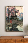 Portrait print featuring three figures in traditional attire walking beneath a blossoming cherry tree near a pavilion reflected in water
