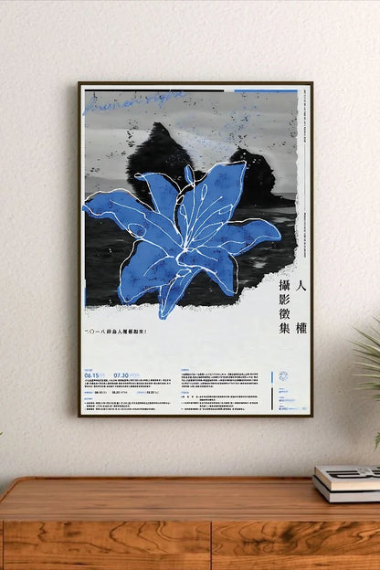 Portrait poster featuring a bold blue lily with white outlines against a black-and-white textured background; vertical Chinese characters on right