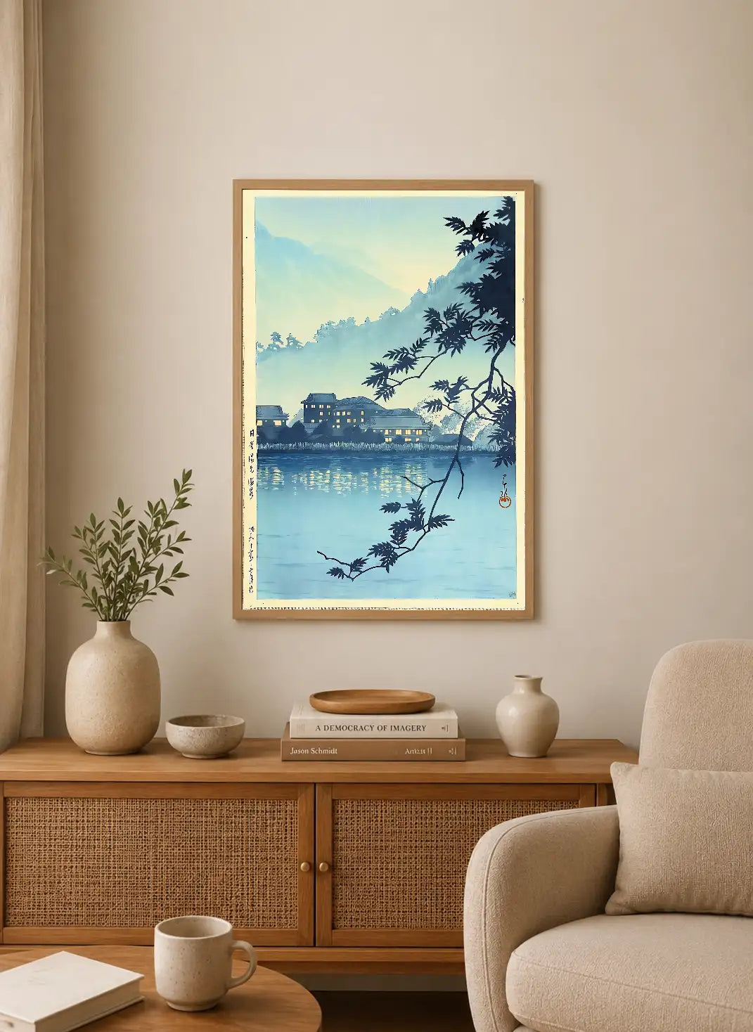 Portrait print depicts tranquil lake with distant village lights reflected in water, framed by dark silhouetted branches against soft blue and pale