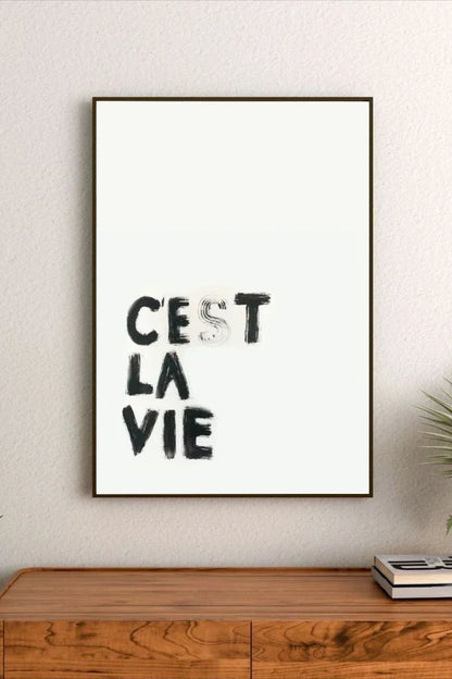 Portrait wall art print featuring minimalist black text on a neutral backdrop, displayed in a modern room setting with light walls