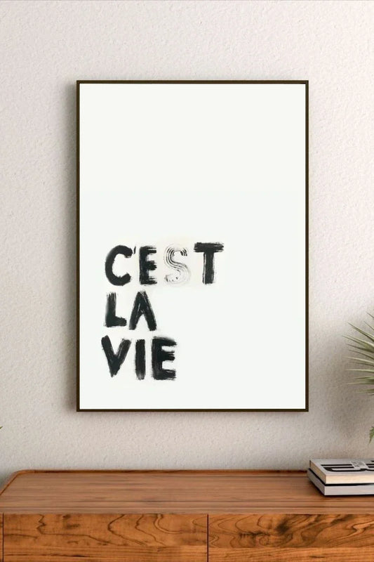 Portrait wall art print featuring minimalist black text on a neutral backdrop, displayed in a modern room setting with light walls