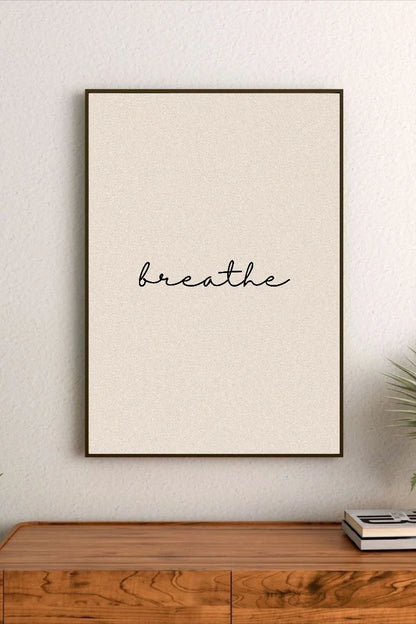 Portrait poster with minimalist black cursive script reading "breathe" on a textured cream background