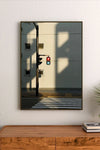 Portrait print featuring a traffic light with red and green signals against a building facade with small windows