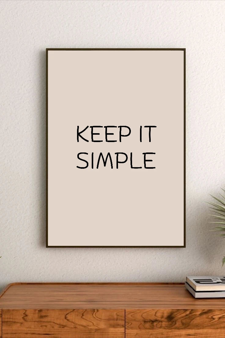 Portrait poster with beige background and black handwritten-style text reading "KEEP IT SIMPLE" in centered upper-middle position