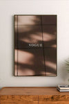 Monochromatic abstract wall art with layered distressed text, symbols, and dark geometric shapes against a pale background surface