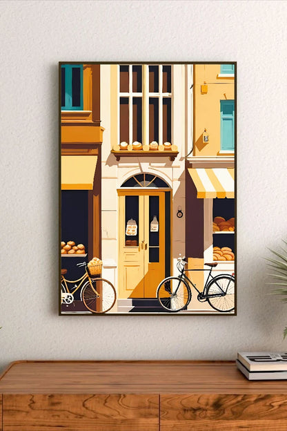 Portrait poster depicting a European street scene with pastel yellow buildings, bicycles, bakery displays, and window shelves holding bread rolls